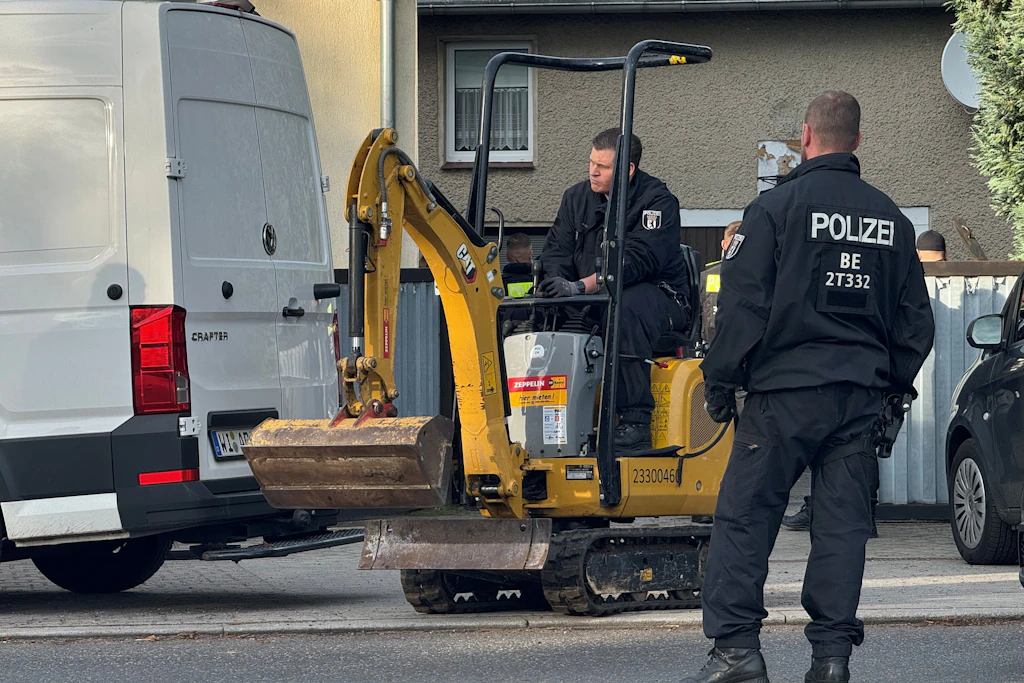 Mird-Fall Rebecca: Ein Polizist fährt den Mini-Bagger vom Grundstück.
