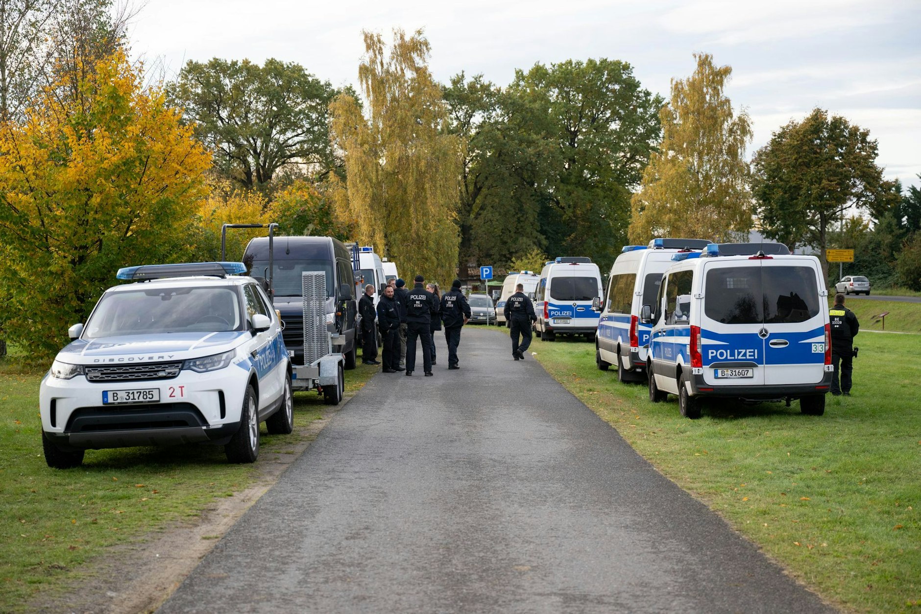 Polizeiautos stehen auf einer Wiese in Tauche (Landkreis Oder-Spree). Im Fall der seit mehr als sechs Jahren vermissten Rebecca aus Berlin-Neukölln hat die Polizei auf einem Grundstück nach Beweismitteln gesucht.