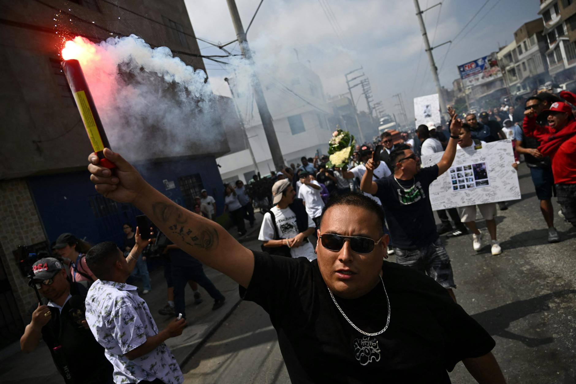 Ein Mann zündet eine Leuchtrakete an, während er den Sarg von Eduardo Ruiz begleitet, einem Demonstranten und Rapper, der am 15. Oktober während eines Protests in Peru getötet wurde.