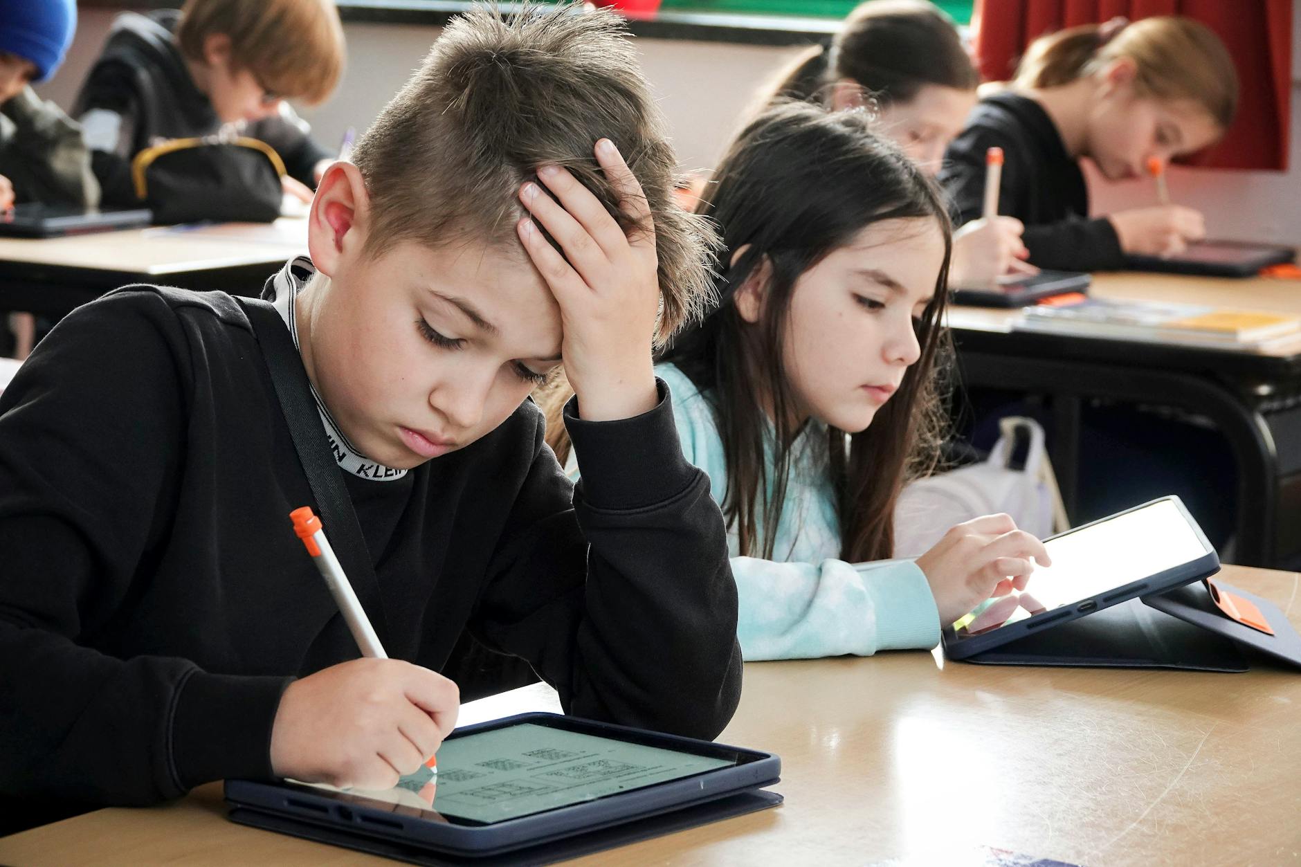 Schüler arbeiten während des Unterrichts an einem Tablet.