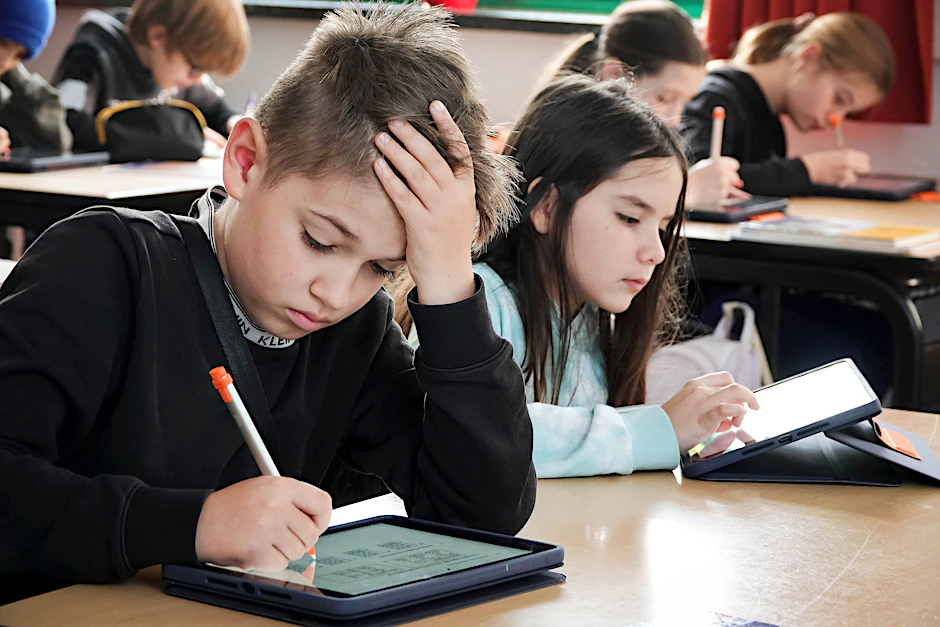 Schüler arbeiten während des Unterrichts an einem Tablet.