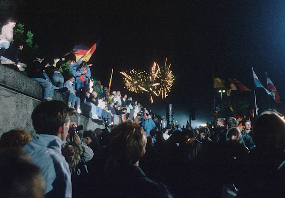 Menschen feiern am 9. November auf der Berliner Mauer.