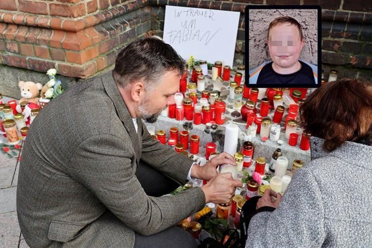 Trauer um Fabian (†8) vor der Kirche in Güstrow: Pastor Jens-Peter Schulz hilft einer Frau beim Anzünden eines Grablichtes.