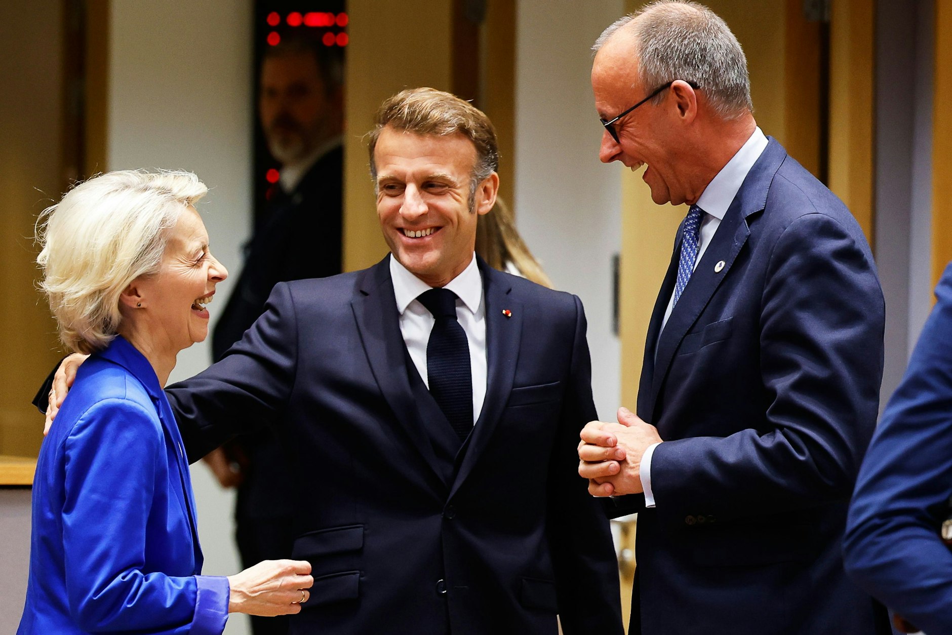 23.10.2025, Brüssel: Bundeskanzler Friedrich Merz spricht mit dem französischen Präsidenten Emmanuel Macron und Ursula von der Leyen, Präsidentin der Europäischen Kommission.