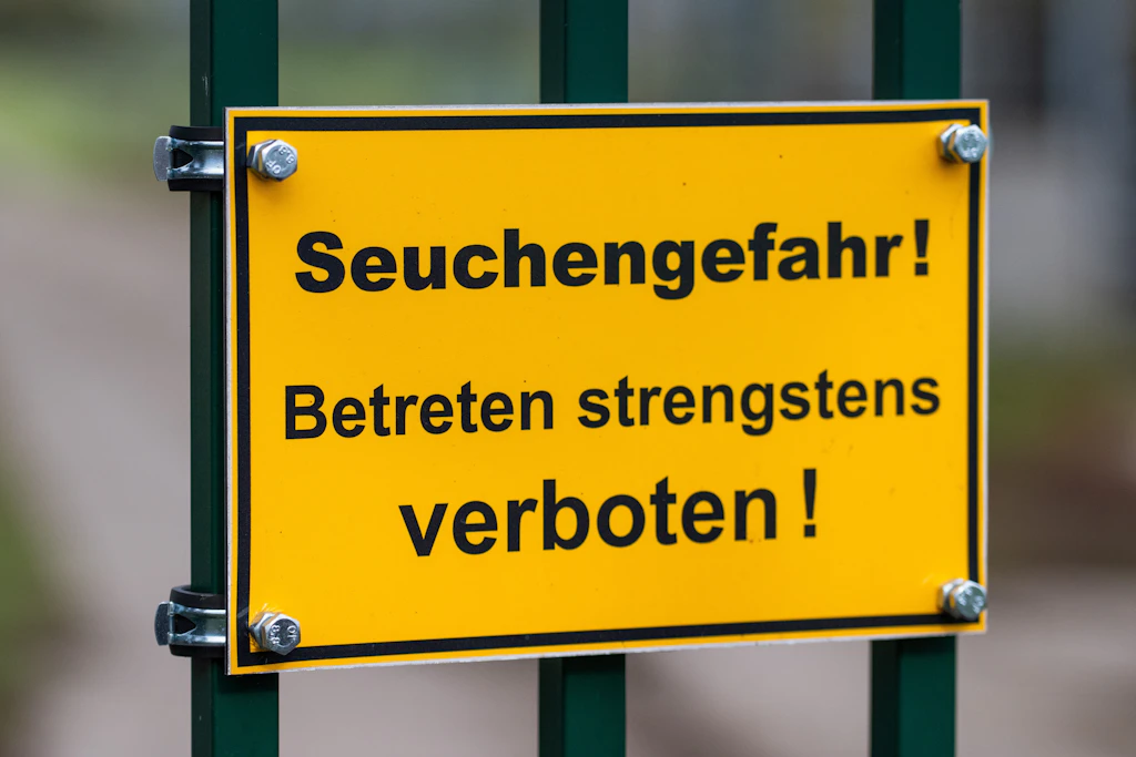 An einem Tor in einem Seuchen-Sperrgebiet in der Nähe von Linum (Fehrbellin) steht ein Schild mit der Aufschrift „Seuchengefahr! Betreten strengstens verboten!“.