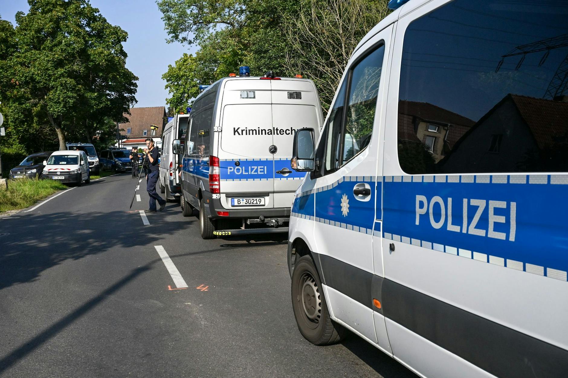 JenEinsatzwagen der Polizei stehen in unmittelbarer Nähe vom beschädigten Strommast im Königsheideweg. Seit dem Brandanschlag ist die Straße für den Autoverkehr gesperrt.