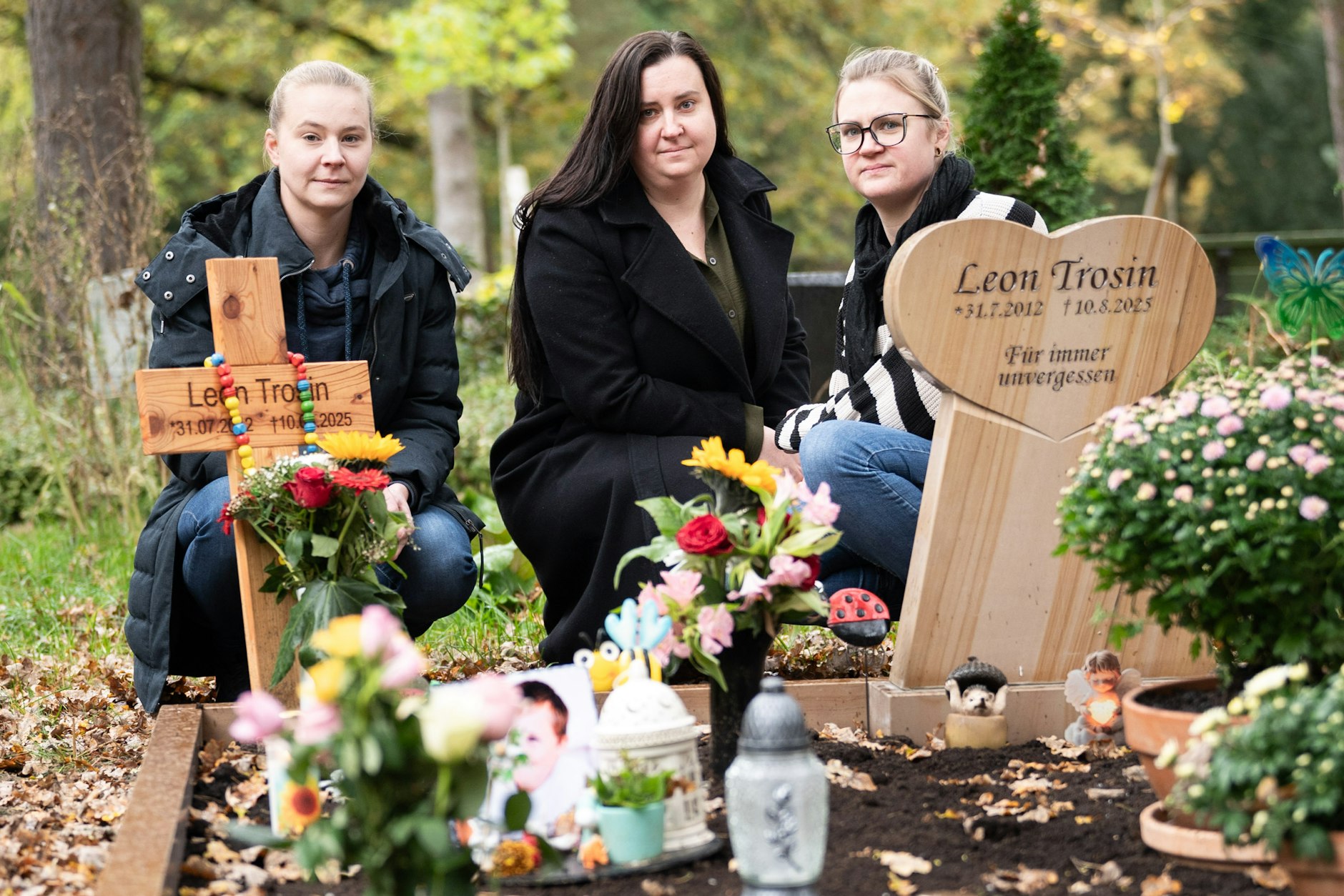 Mittlerweile hat der Steinmetz einen würdigen Gedenkstein aufgestellt. Leons Mutter Sabrina Trosin  (M.) und ihre Schwestern Katharina (r.) und Alexandra (l.) auf dem Friedhof.