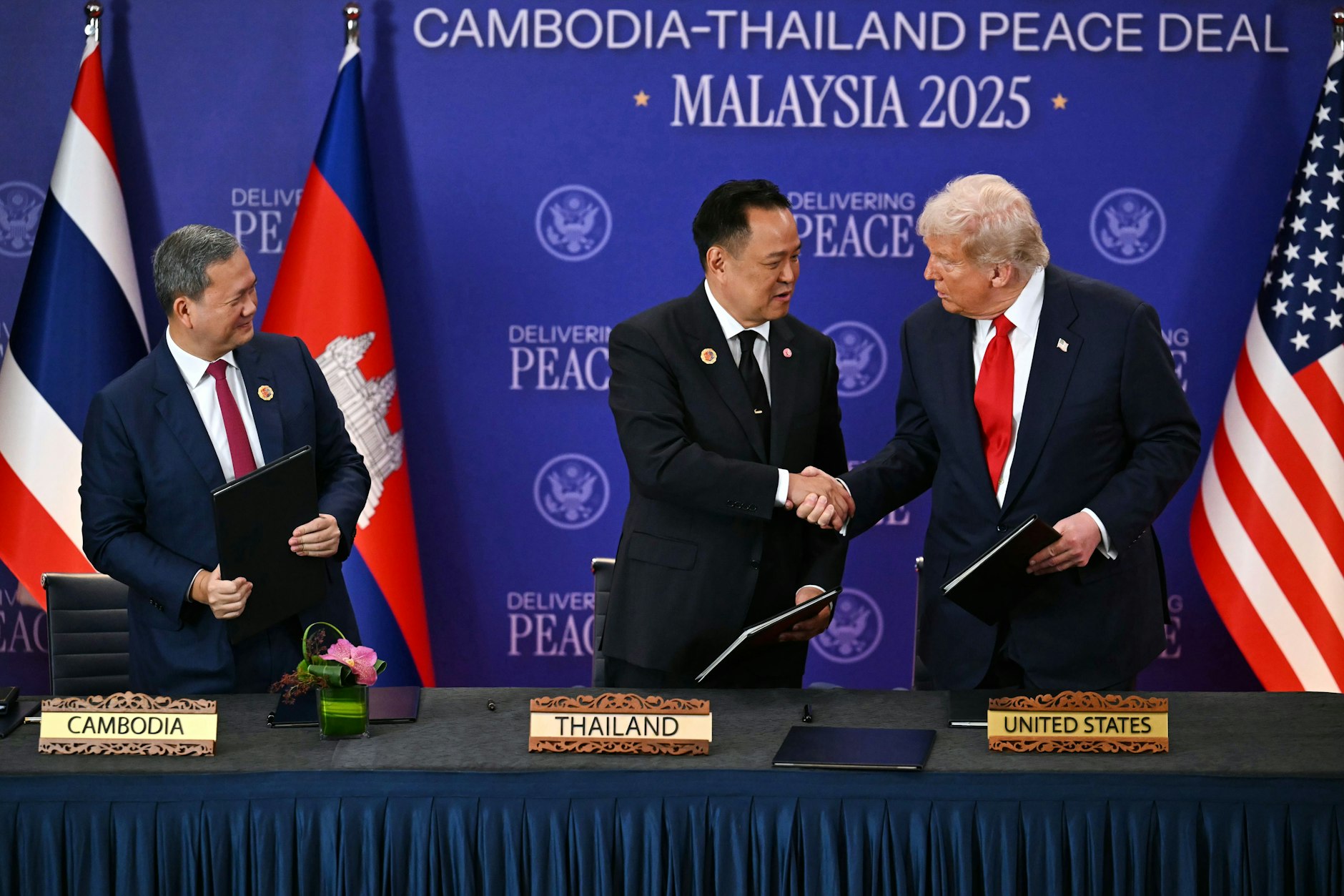 Kambodschas Premierminister Hun Manet (l) beobachtet den thailändischen Premierminister Anutin Charnvirakul und US-Präsident Donald Trump beim Händeschütteln am Rande des Asean-Gipfeltreffens.