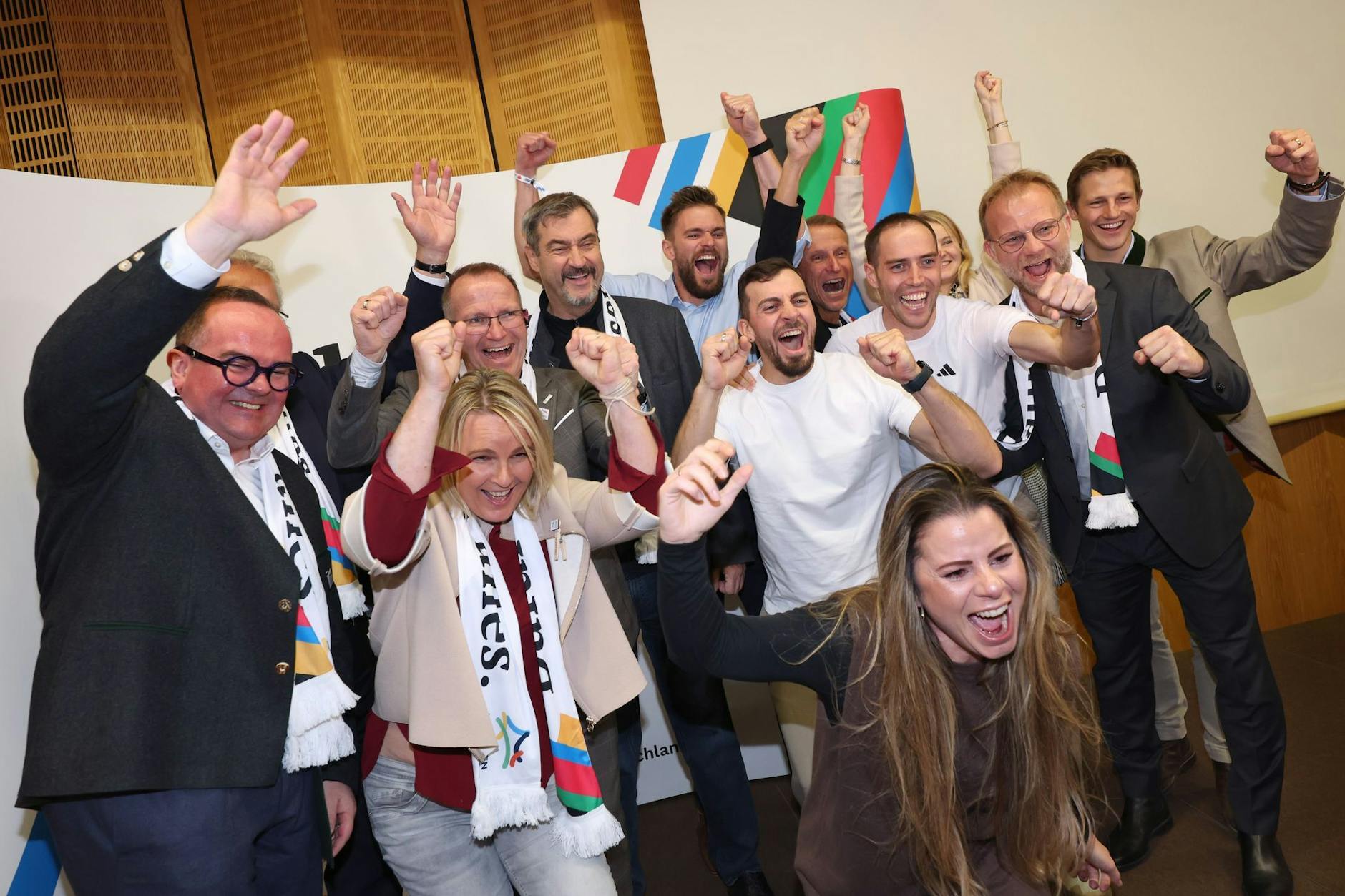 Markus Söder (CSU, 4.v.l), Bayerns Ministerpräsident, jubelt mit Mitstreitern in München