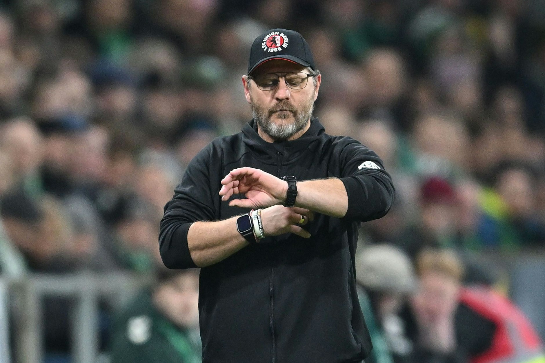 Trainer Steffen Baumgart vom 1. FC Union schaut auf die Uhr.