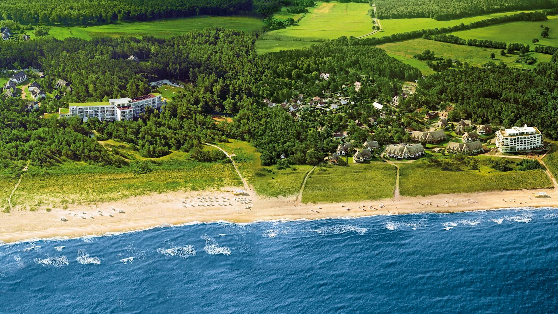 Das Strandhotel Fischland, links umgeben von Küstenwald, ehemals Gästehaus der DDR-Regierung, 800 Meter entfernt das nah am Strand gelegene Strandhotel Dünenmeer. Zu beiden Schwesterhotels gehören Ferienhäuser und -wohnungen.