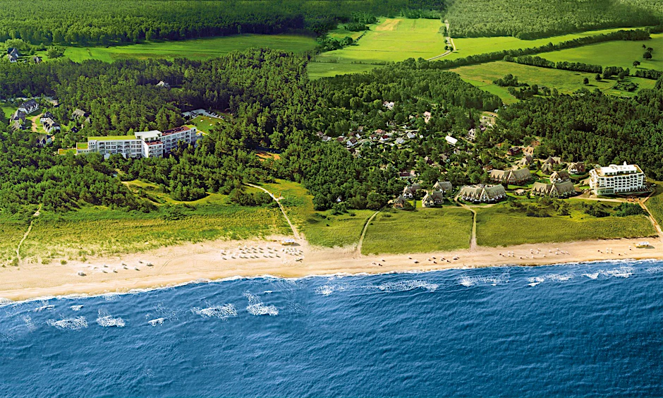 Das Strandhotel Fischland, links umgeben von Küstenwald, ehemals Gästehaus der DDR-Regierung, 800 Meter entfernt das nah am Strand gelegene Strandhotel Dünenmeer. Zu beiden Schwesterhotels gehören Ferienhäuser und -wohnungen.