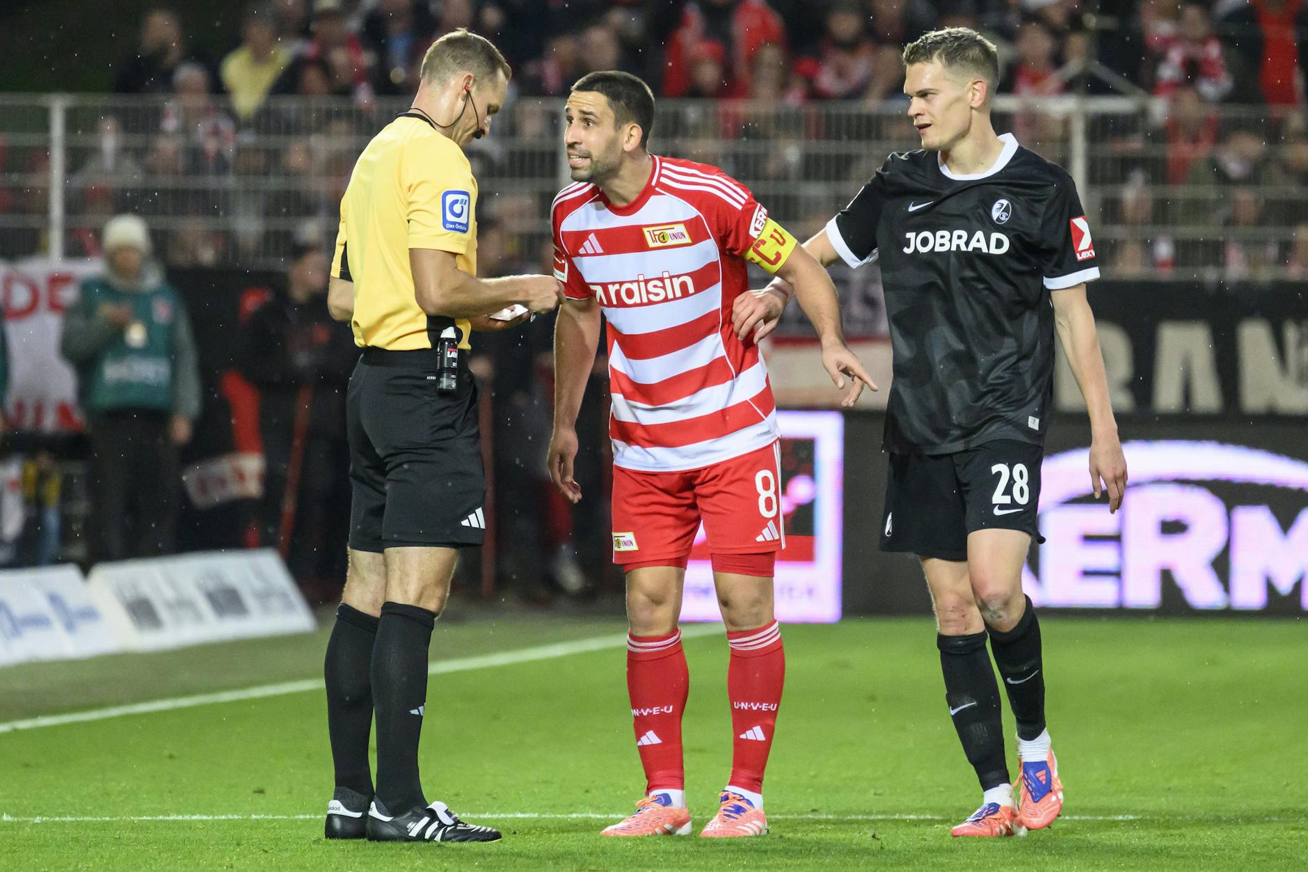 Rani Khedira (Mitte) diskutiert mit Schiedsrichter Sören Storks in der Partie gegen den SC Freiburg.