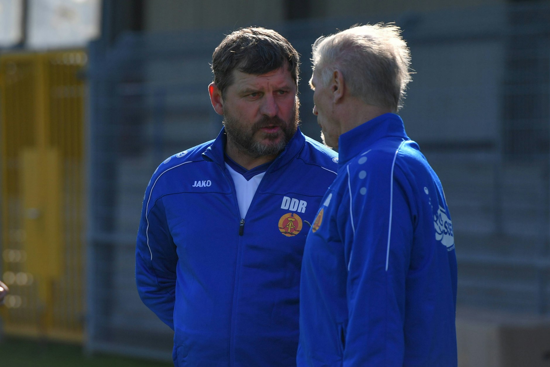 Steffen Baumgart trägt 2021 bei einem Benefizspiel der Ost-Legenden gegen eine Auswahl aus Ostfriesland eine DDR-Jacke.