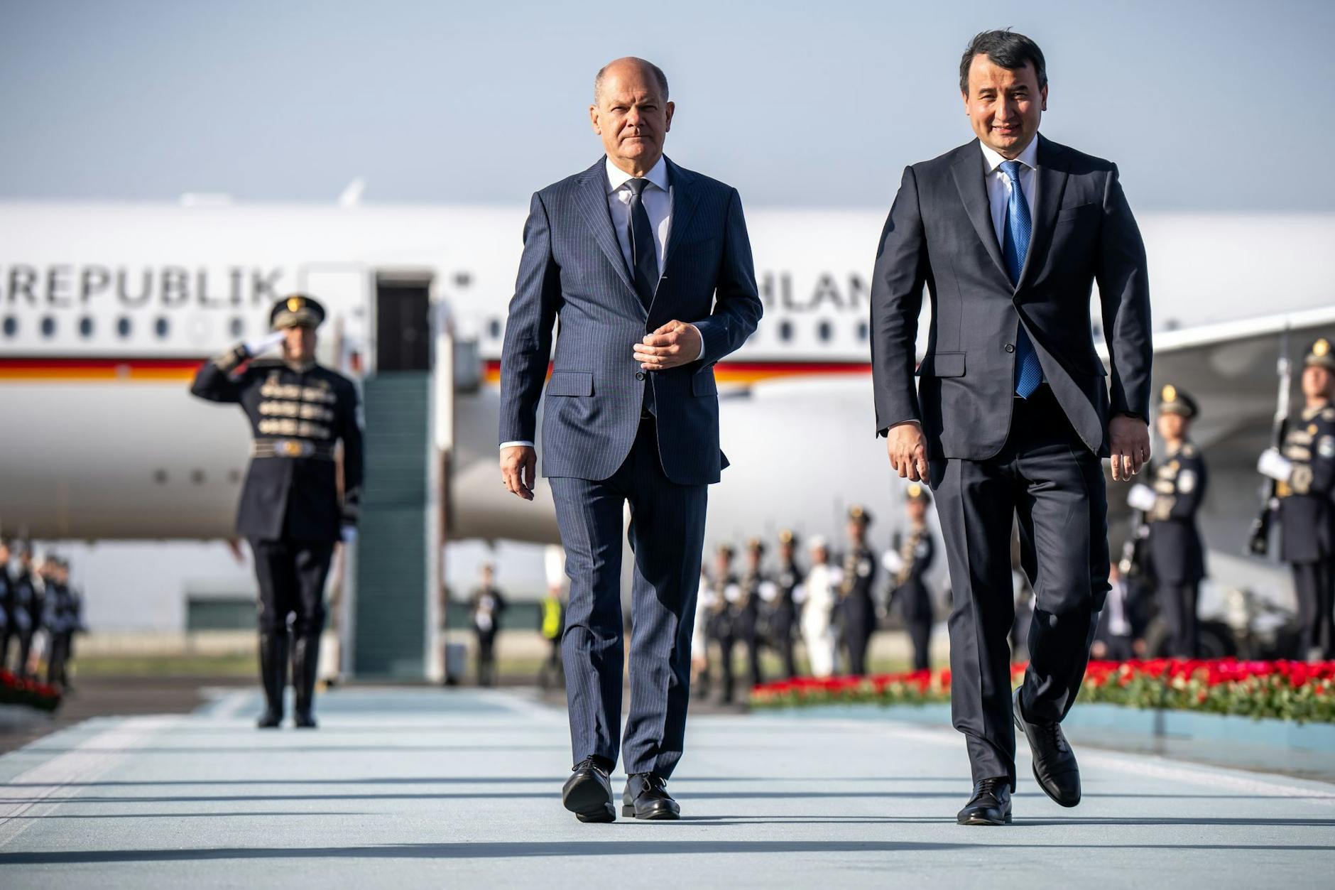 Bundeskanzler Olaf Scholz wird bei seinem Besuch 2024 am Flughafen von Abdulla Aripow, Ministerpräsident von Usbekistan begrüsst.