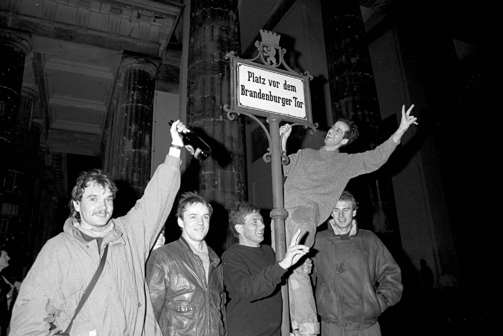 Berliner Mauer 1989: Nach der Maueröffnung feiern Ost- und Westberliner ein Wiedersehen am Brandenburger Tor.