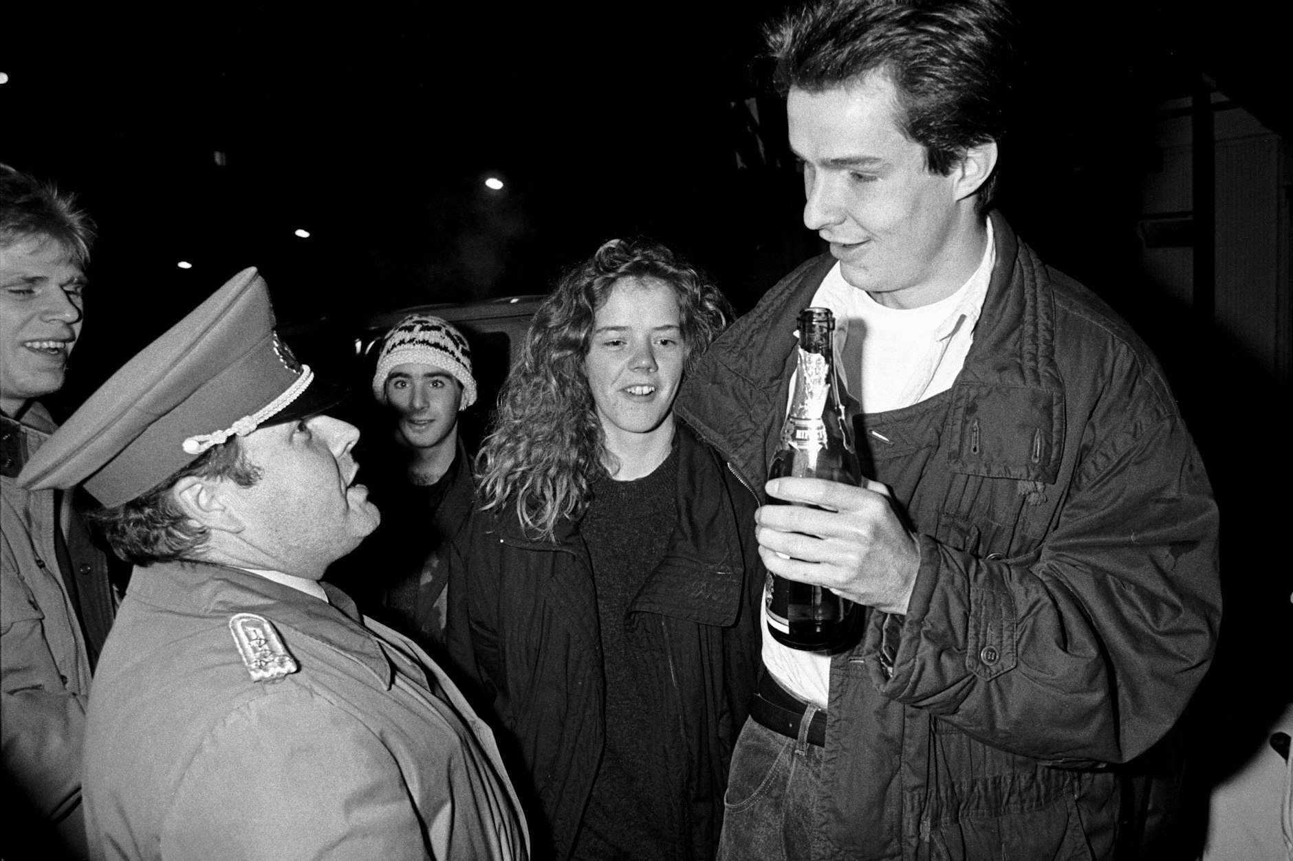 Ein DDR-Grenzsoldat mit feiernden Ost-Berlinern am Grenzübergang in der Invalidenstraße in Berlin-Mitte.