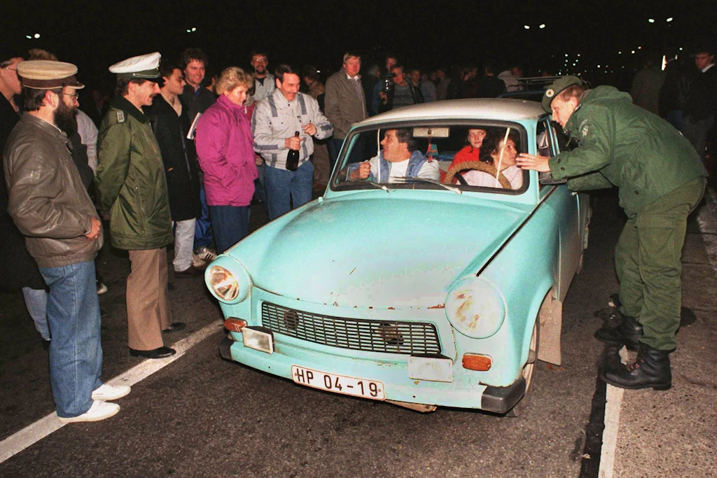 Das Archivbild vom 10. November zeigt, wie ein Beamter des Bundesgrenzschutzes einem DDR-Autofahrer am Grenzübergang Helmstedt eine Auskunft gibt.