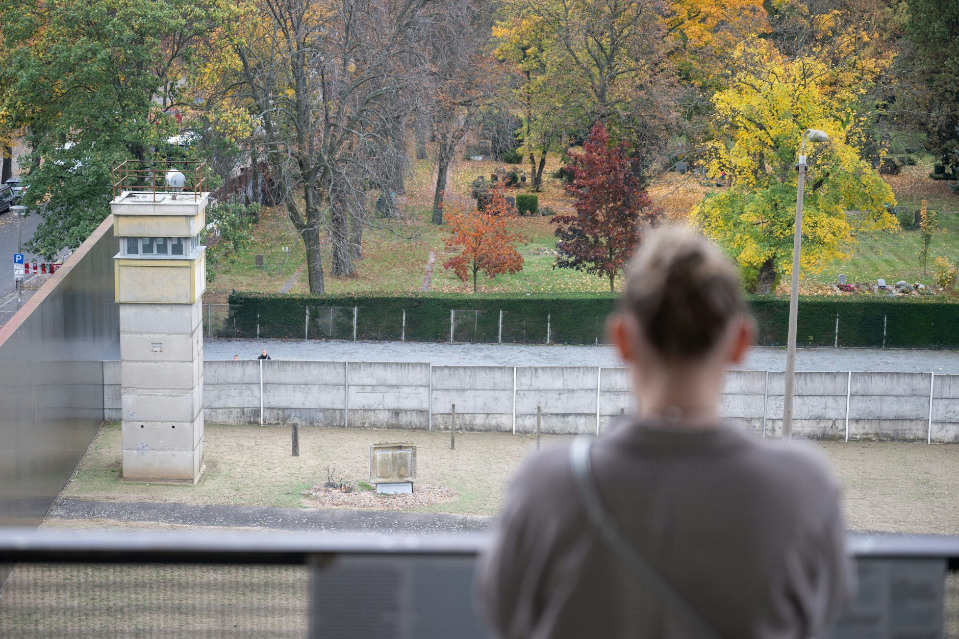 Eine Besucherin blickt an der Gedenkstätte Berliner Mauer in der Bernauer Straße auf den Rest der Mauerkonstruktion.