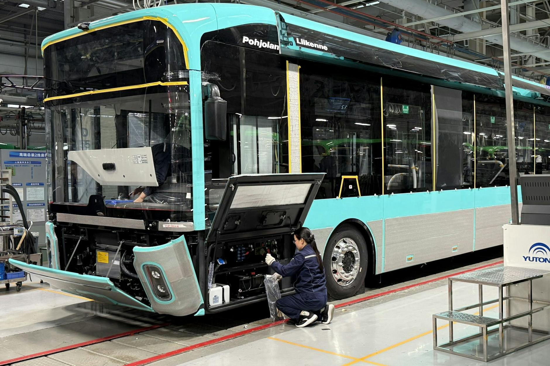 Eine Yutong-Mitarbeiterin montiert ein Schaltmodul in einen E-Bus, der für den Einsatz in Finnland vorgesehen ist.