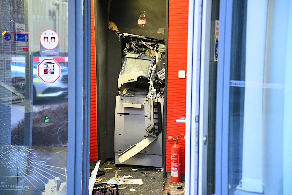 Ein gesprengter Geldautomat ist in einem Bankgebäude zu sehen. 