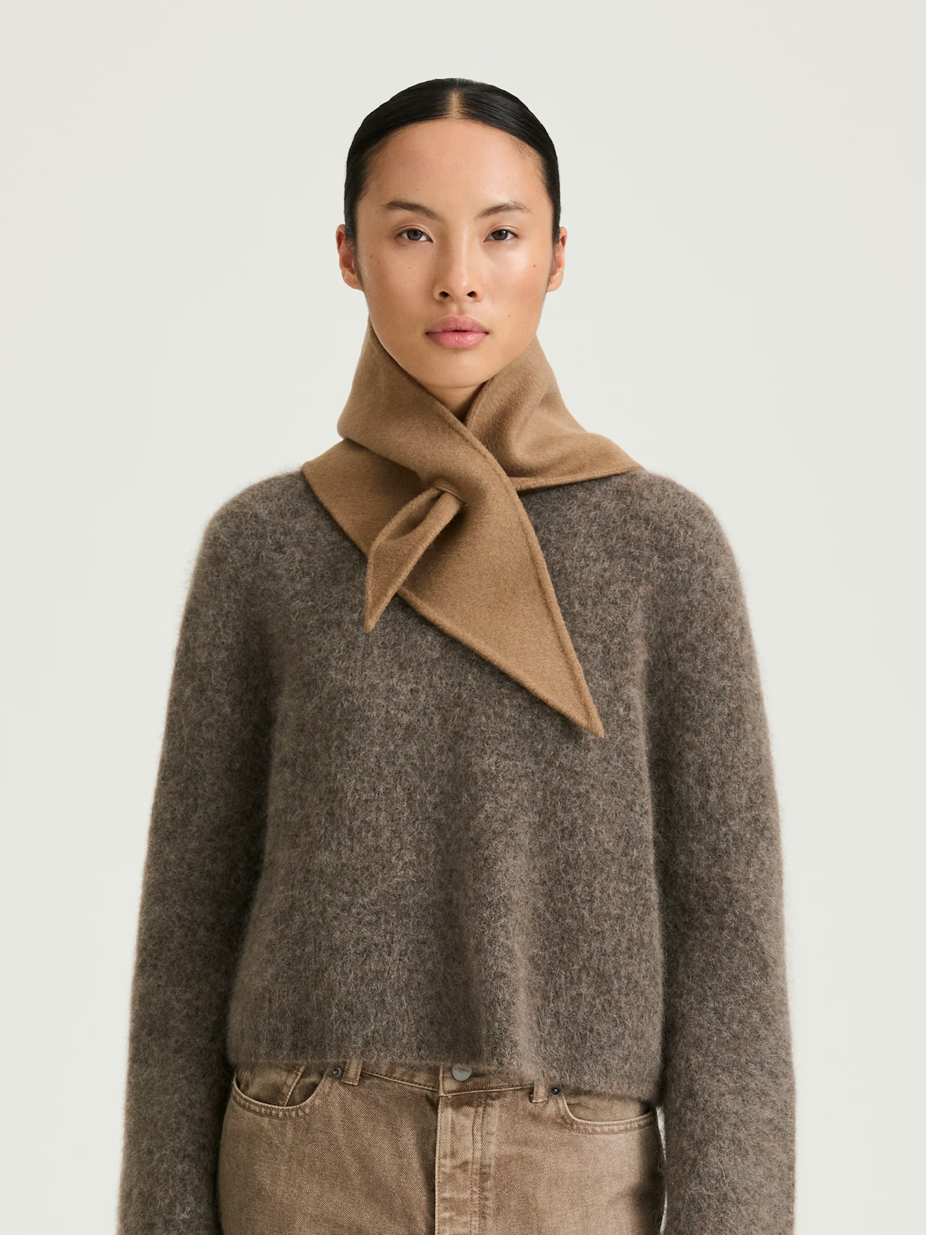 Треугольный шарф Trinity от Stylein бежевого цвета изготовлен из чистого кашемира и просто протягивается через петлю.