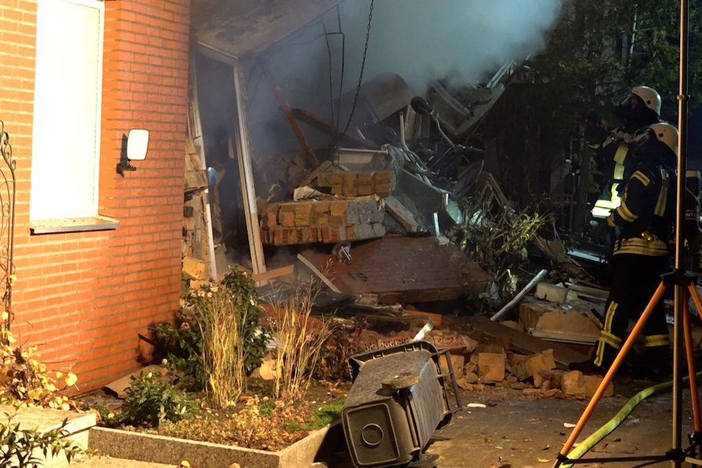 Feuerwehrleute sind im Einsatz am zerstörten Reihenhaus.