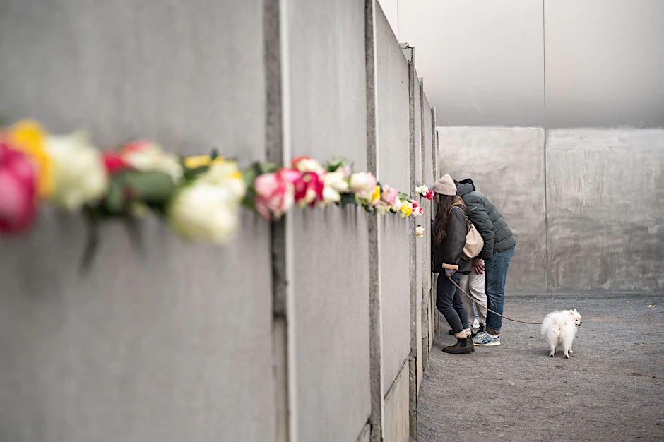 Gedenkstätte Berliner Mauer an der Bernauer Straße: In einen schmalen Spalt werden Blumen gesteckt.