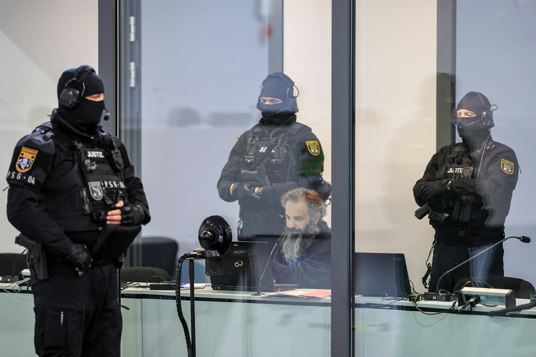 eburg: Der Angeklagte Taleb A. sitzt mit Handfesseln in dem kugelsicheren Glaskasten Gerichtssaal im temporären Gerichtsgebäude des Landgerichtes Magdeburg.