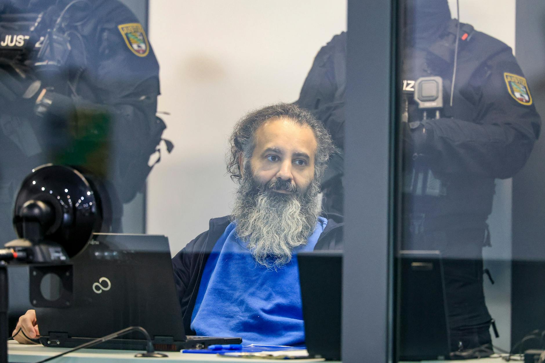 Der Angeklagte Taleb A. sitzt in einem kugelsicheren Glaskasten im Gerichtssaal im temporären Gerichtsgebäude des Landgerichts Magdeburg.