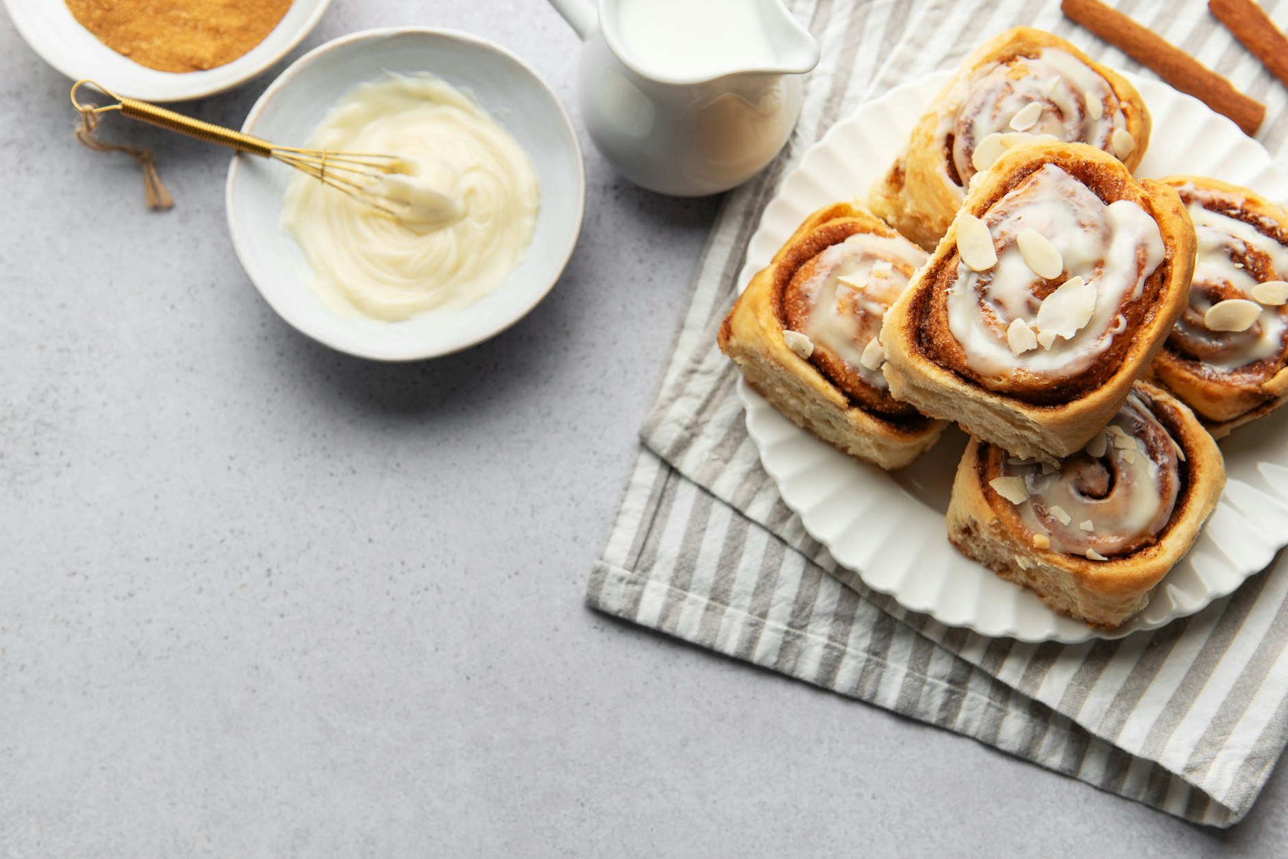 Frisch gebackene Zimtschnecken mit Zuckerguss und Mandelsplittern bestreut.