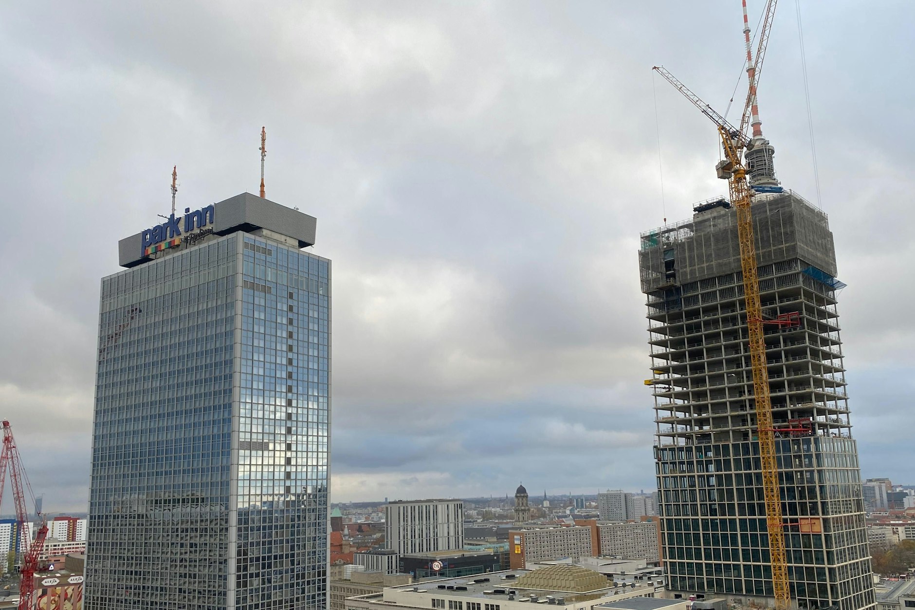 Jetzt hat der neue Wolkenkratzer am Alex den Berliner Fernsehturm fast komplett geschluckt. Es bleibt nur noch die Spitze.