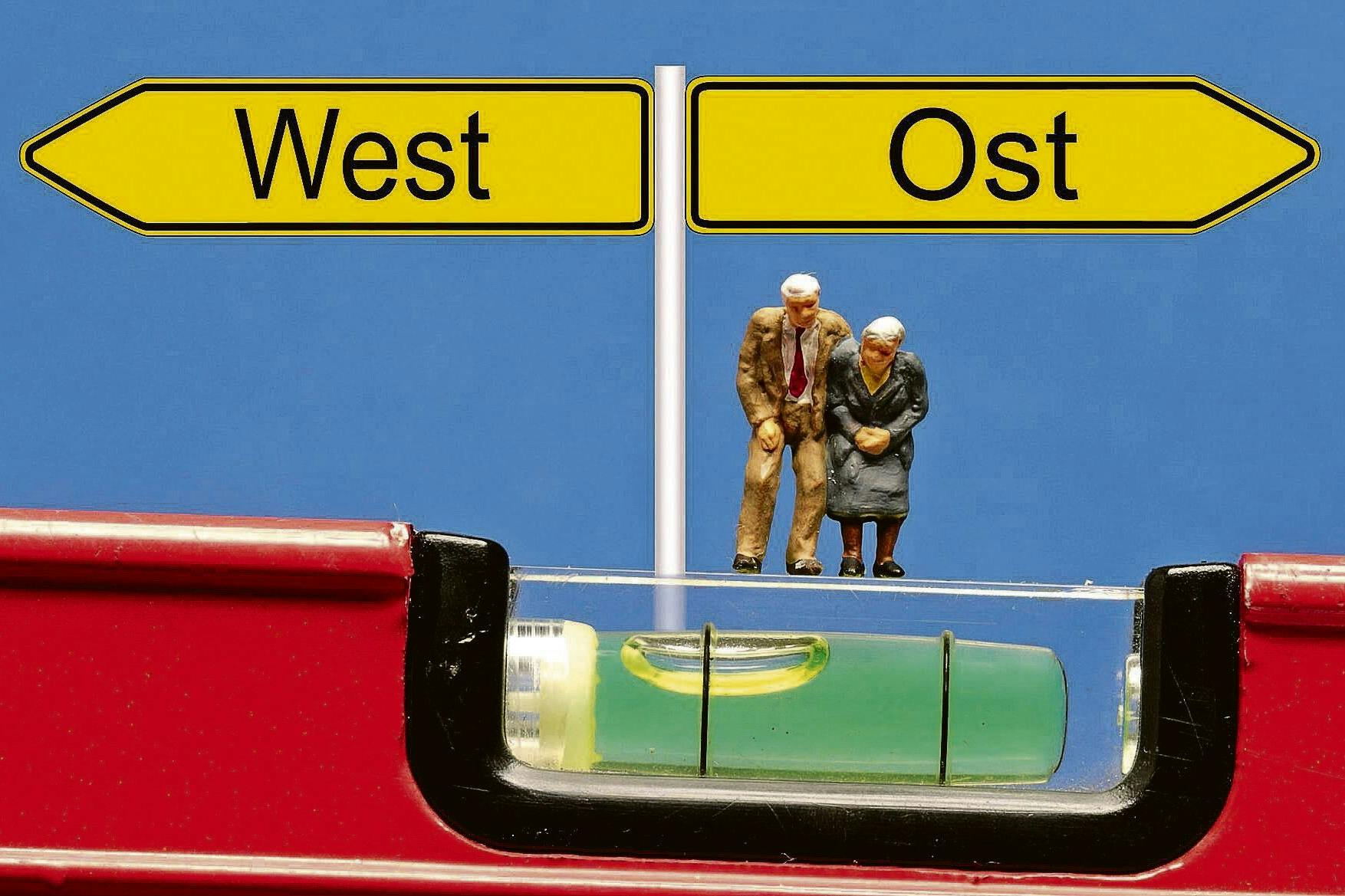 Ost und West im Ungleichgewicht, hier symbolisiert anhand einer Wasserwaage.
