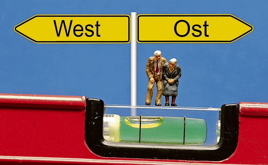Ost und West im Ungleichgewicht, hier symbolisiert anhand einer Wasserwaage.