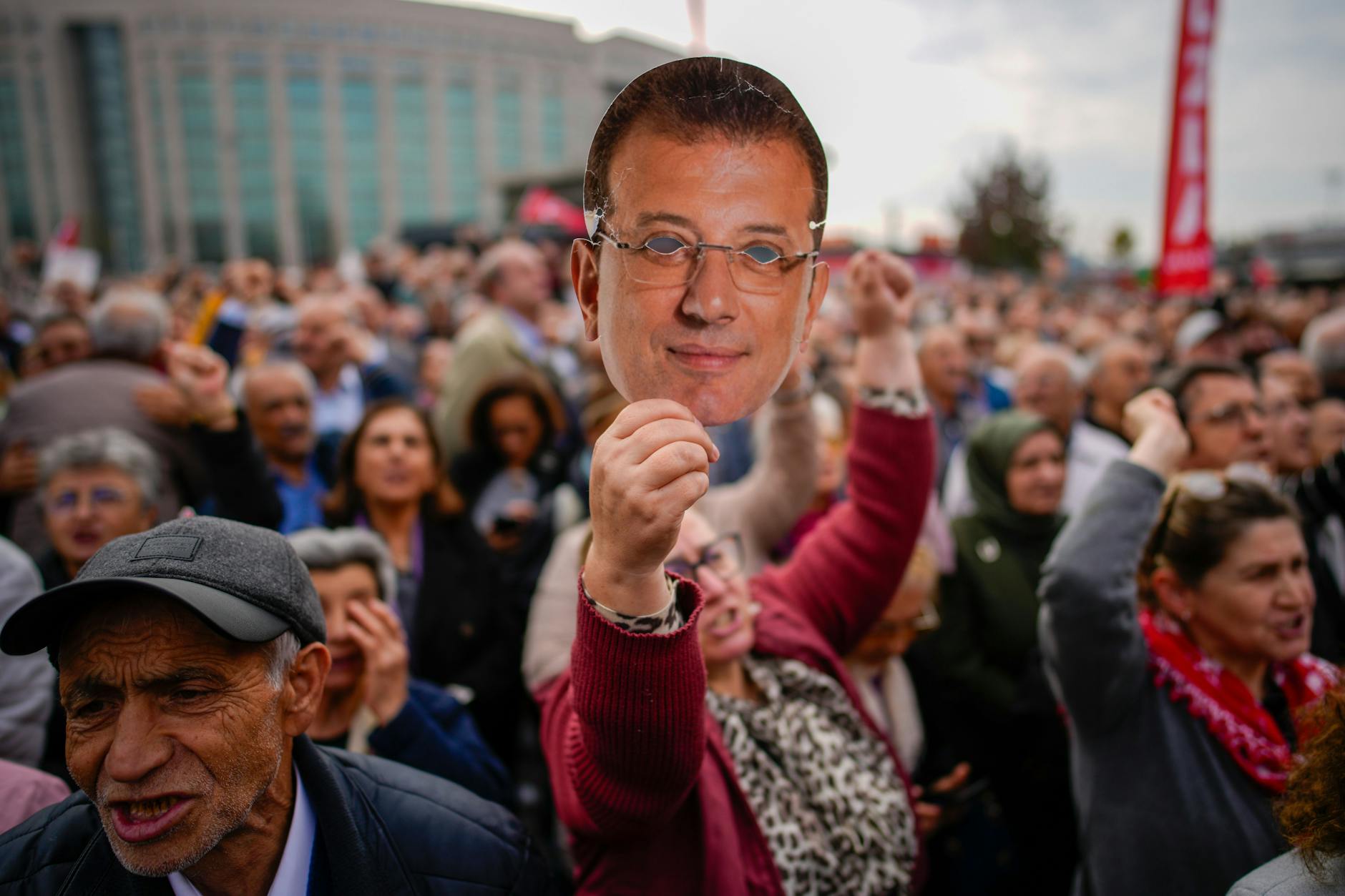 26.10.2025, Türkei, Istanbul: Eine Frau hält eine Maske mit dem Gesicht des inhaftierten oppositionellen Bürgermeisters von Istanbul, Ekrem Imamoglu, während einer Kundgebung zu seiner Unterstützung hoch