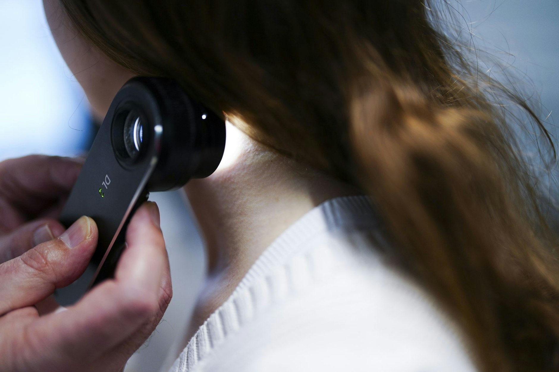 Ein Hautarzt sucht eine Patientin nach bösartigen Hautveränderungen ab. Einige Krankenkassen tragen die Screening-Kosten.