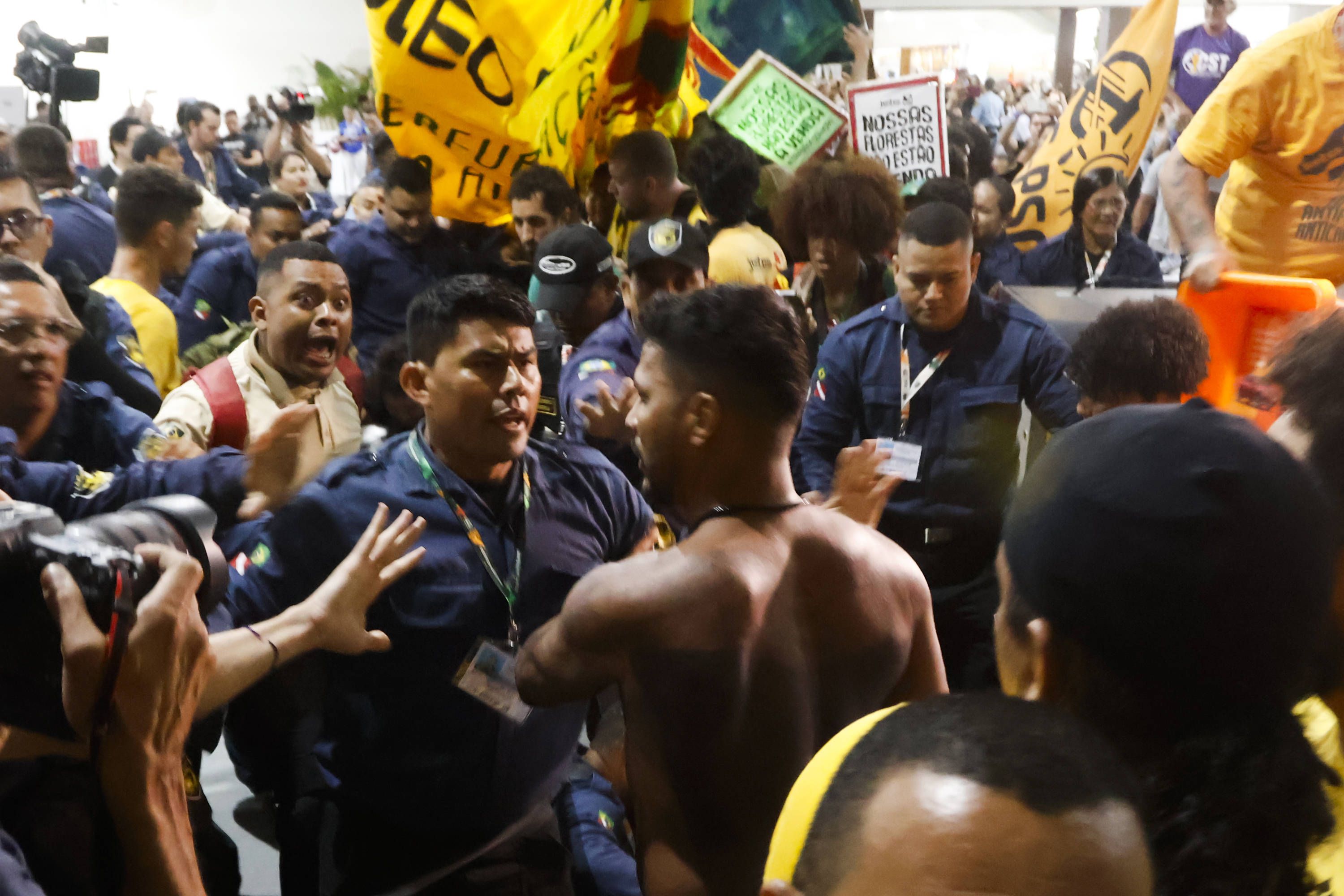 Image - Indigene Demonstranten stürmen COP30-Klimakonferenz: Sicherheitskräfte bauen Barrikade aus Möbeln