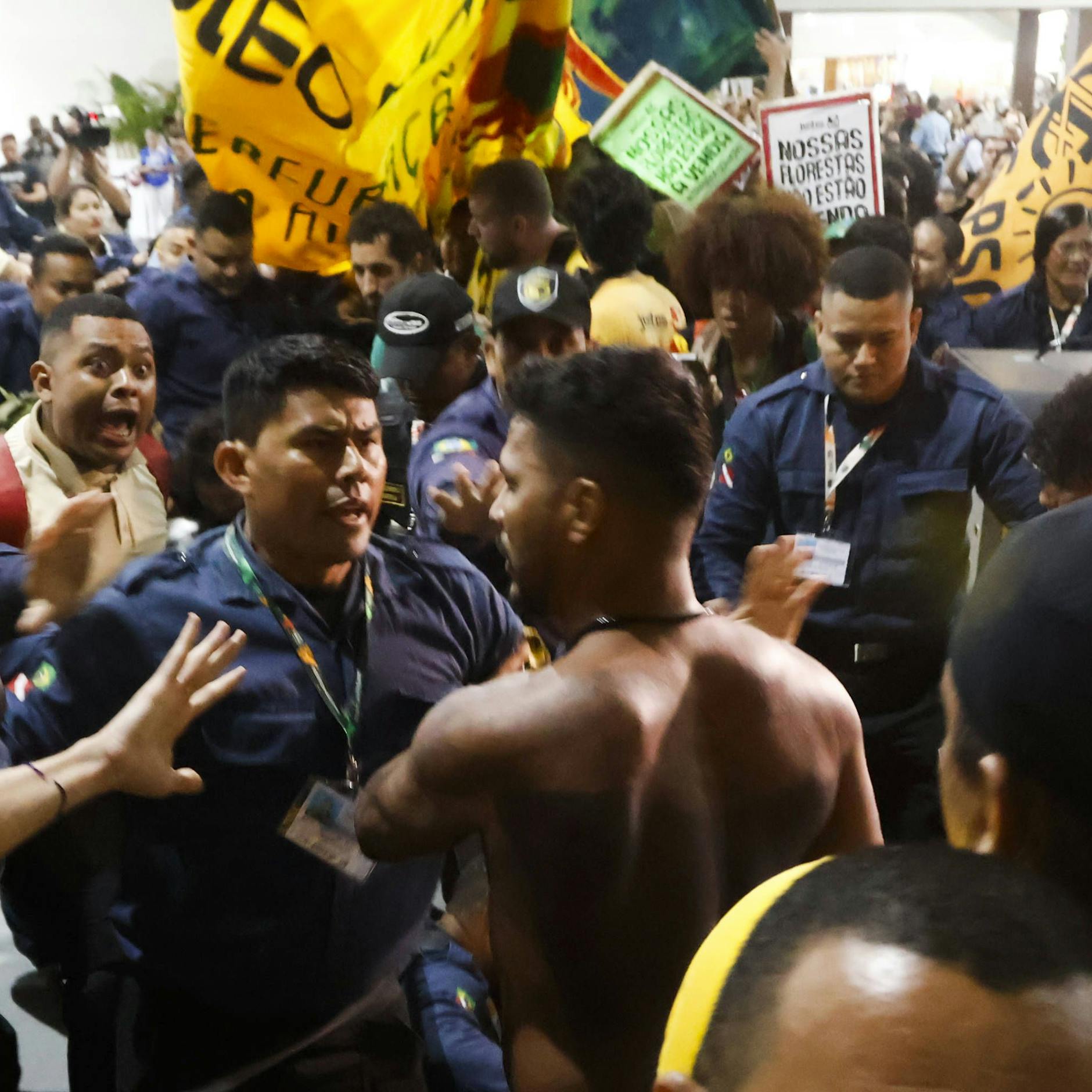 Image - Indigene Demonstranten stürmen COP30-Klimakonferenz: Sicherheitskräfte bauen Barrikade aus Möbeln