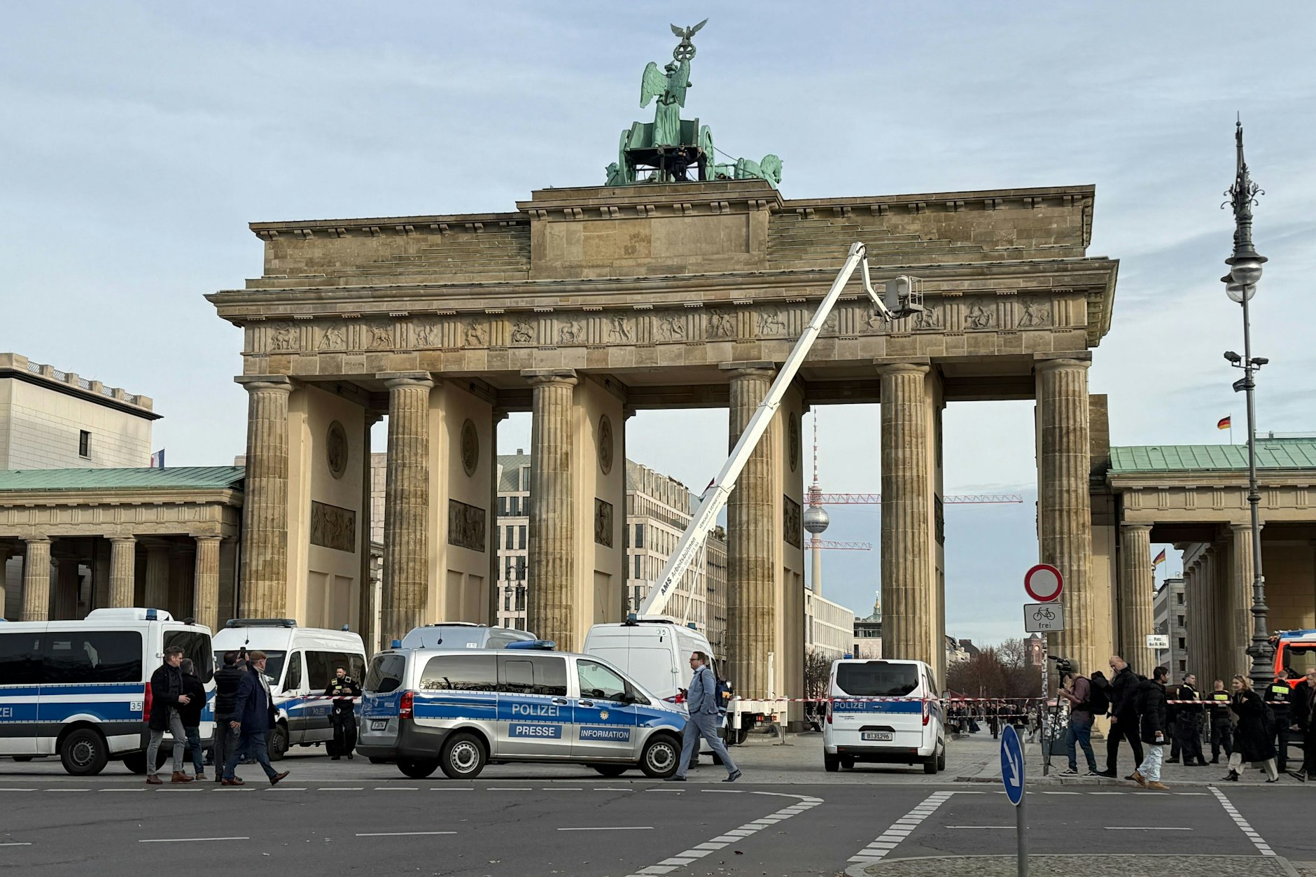 Mit einer Arbeitsbühne fahren Höhenretter der Polizei auf das Brandenburger Tor, um ein Transparent zu entfernen.