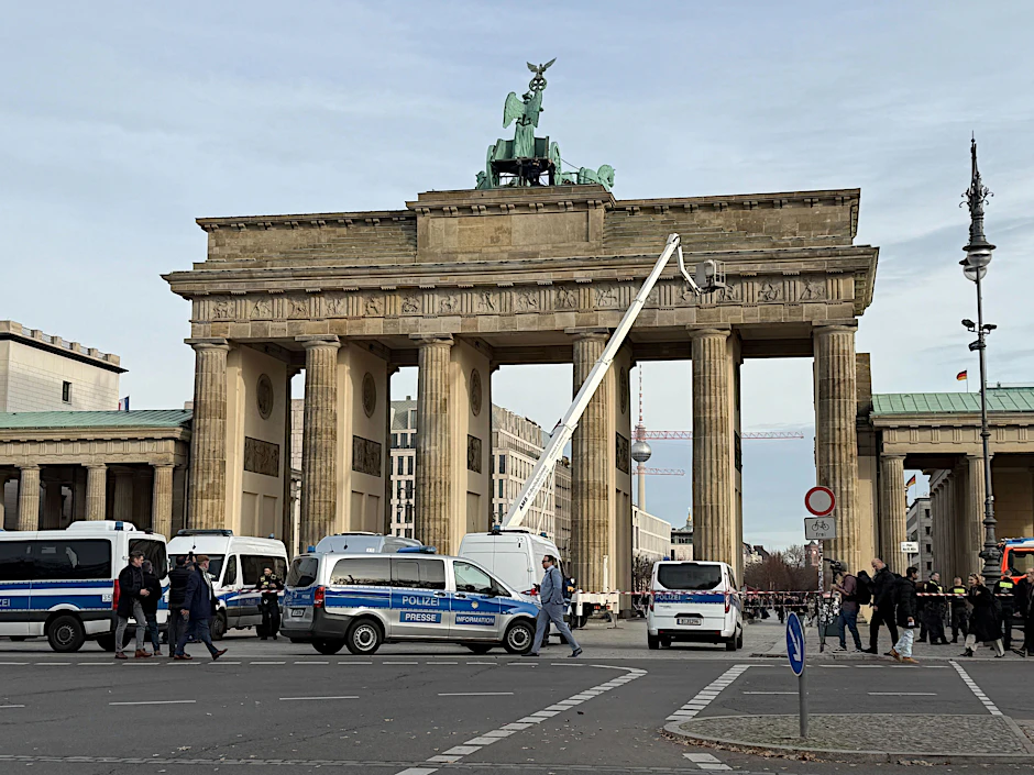 Mit einer Arbeitsbühne fahren Höhenretter der Polizei auf das Brandenburger Tor, um ein Transparent zu entfernen.