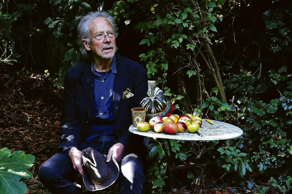 Peter Handke sitzt in seinem Garten bei seinem Haus in Chaville.