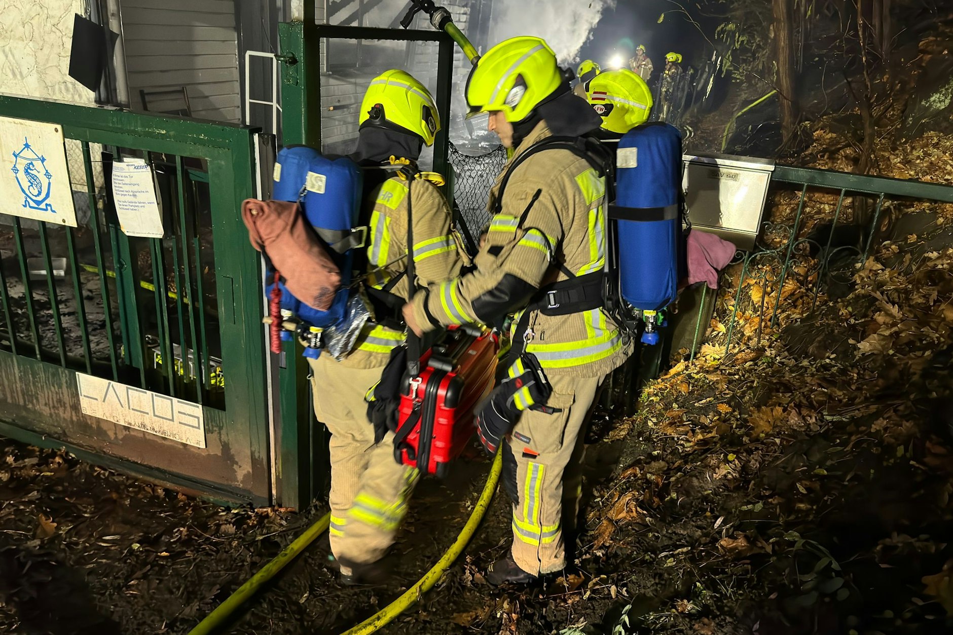 Feuerwehrmänner mit Schläuchen am Einsatzort.