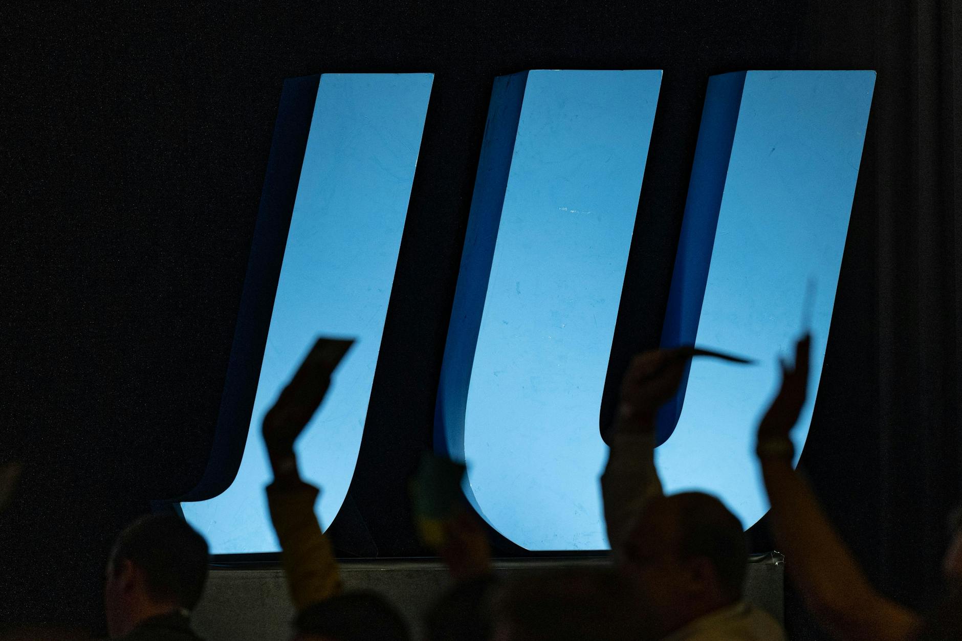 Delegierte heben auf einer Landesversammlung der Jungen Union vor dem Logo der JU ihre Stimmkarten.