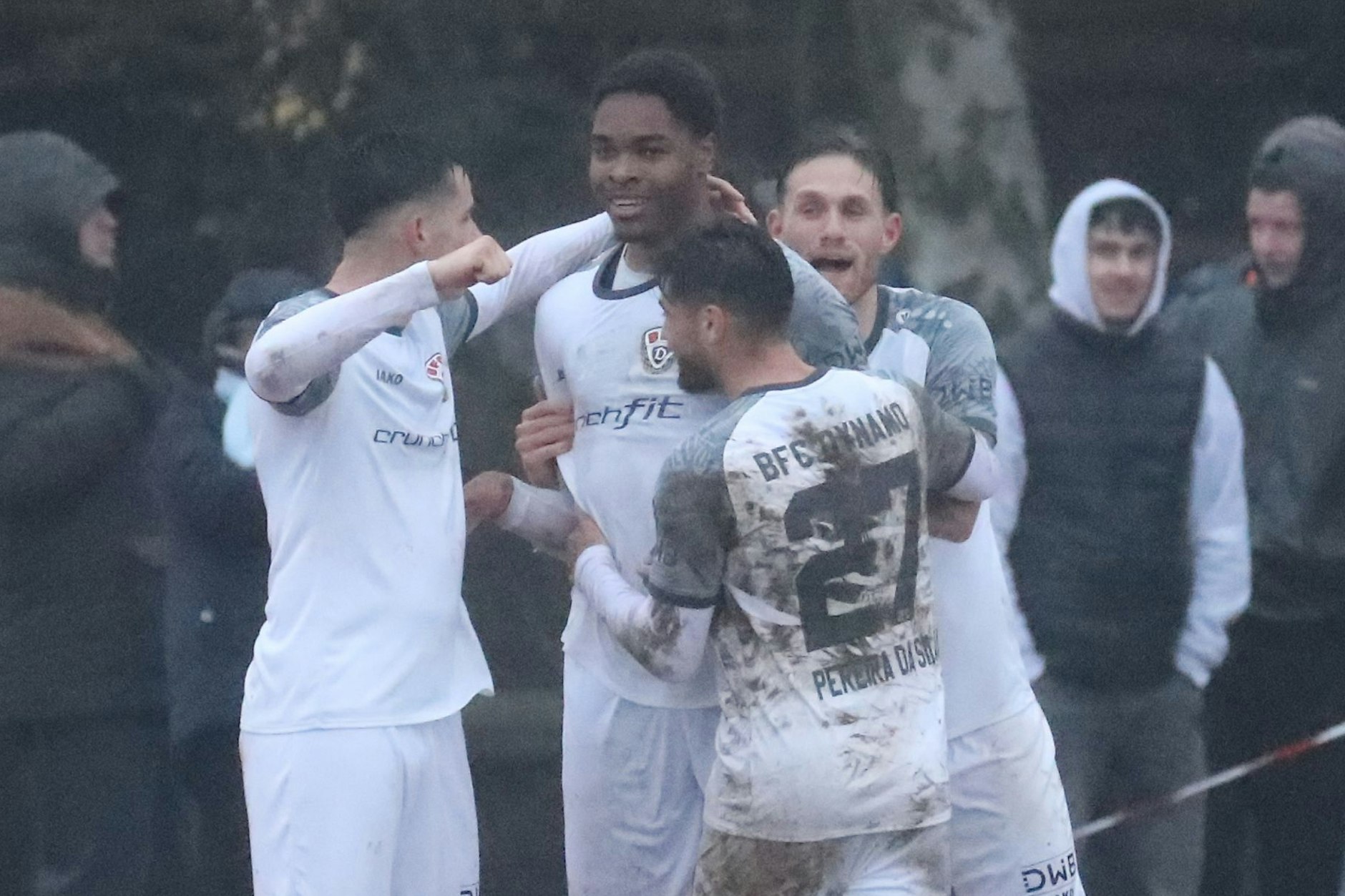 Brandon Happi Monthe (M.) wird von seinen Dynamo-Kollegen gefeiert.