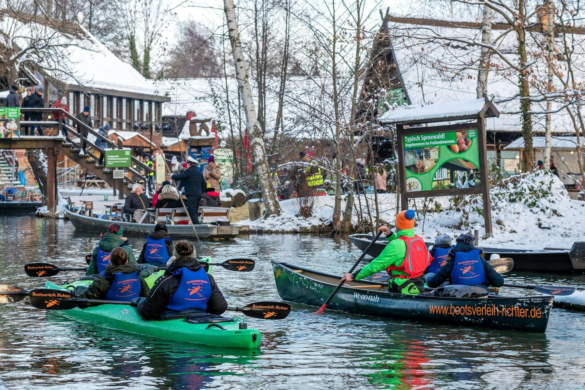 Paddler und Spreewaldkähne erreichen den Hafen des Spreewalddorfes Lehde.