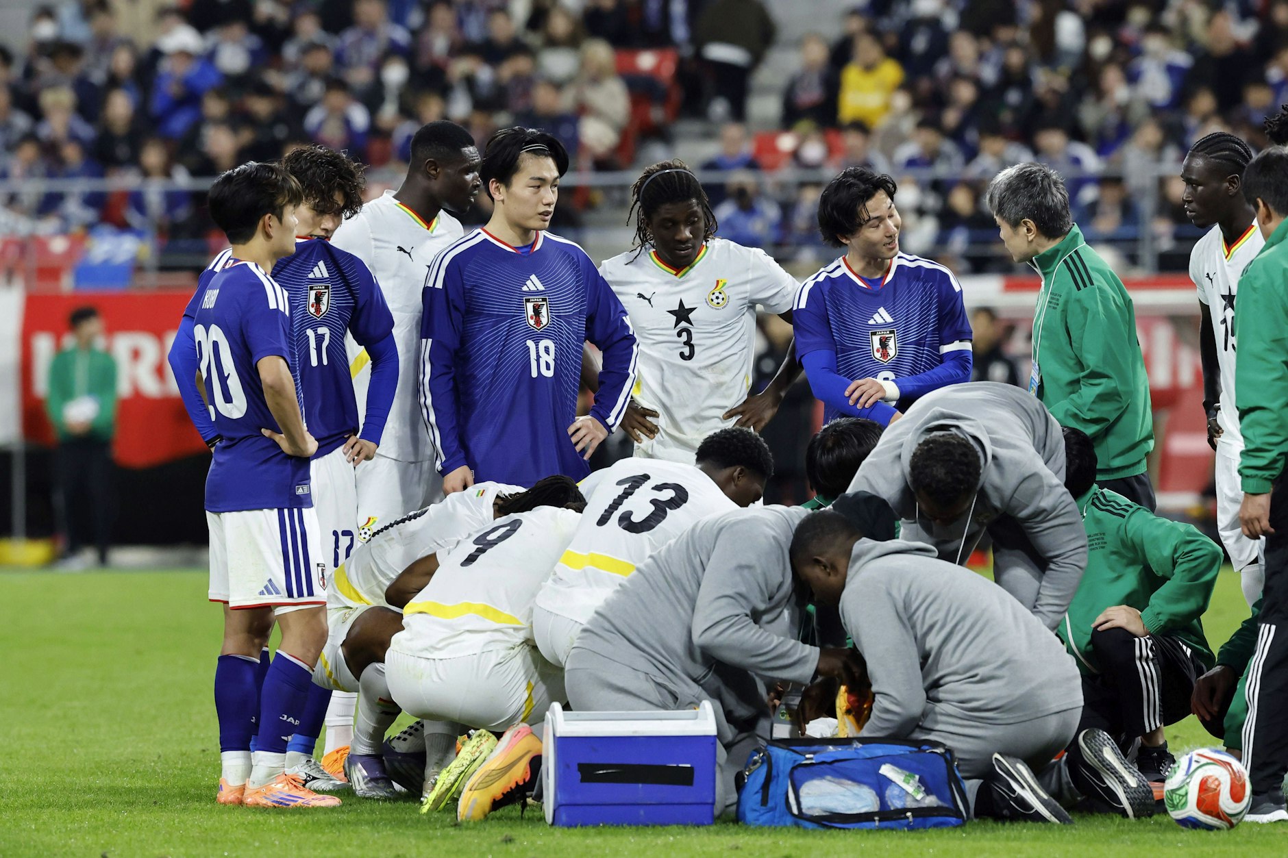 Ghanas Mittelfeldstar Abu Francis (24) verletzt sich im Spiel in Japan schwer. Seine Teamkollegen, darunter Union-Verteidiger Derrick Köhn (Nr. 13), reagieren geschockt.