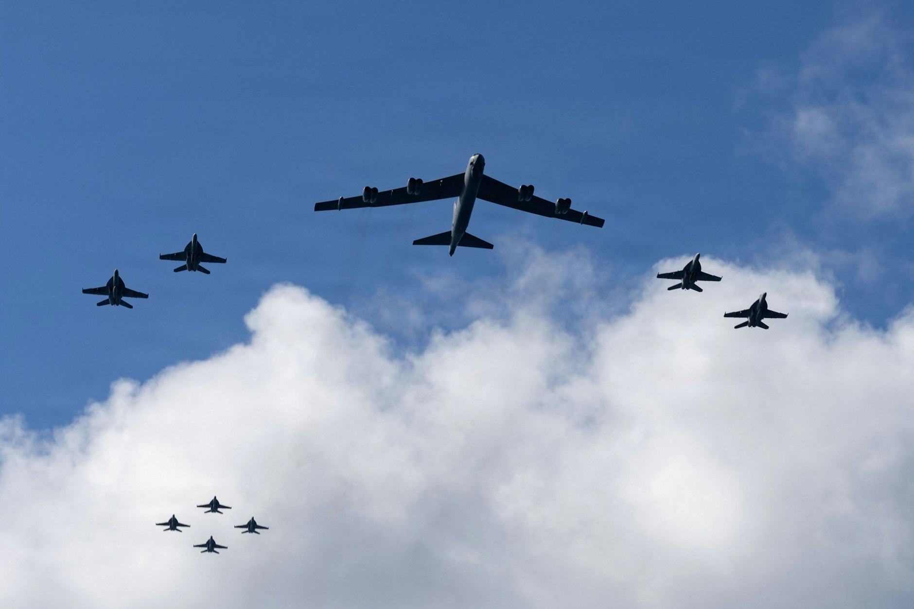 Kampfjets begleiten einen US-Bomber vom Typ B-52.