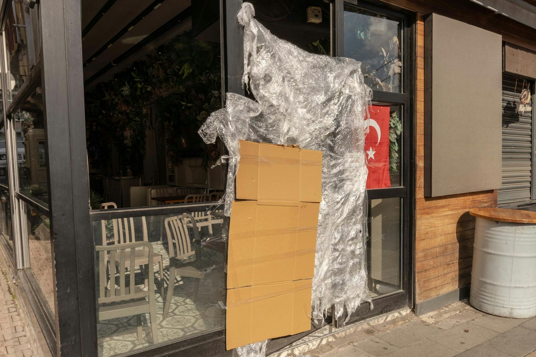 An einem türkischen Stand für Streetfood, der von den türkischen Behörden geschlossen wurde, hängen eine Pappe und eine Plastikplane neben einer türkischen Fahne.