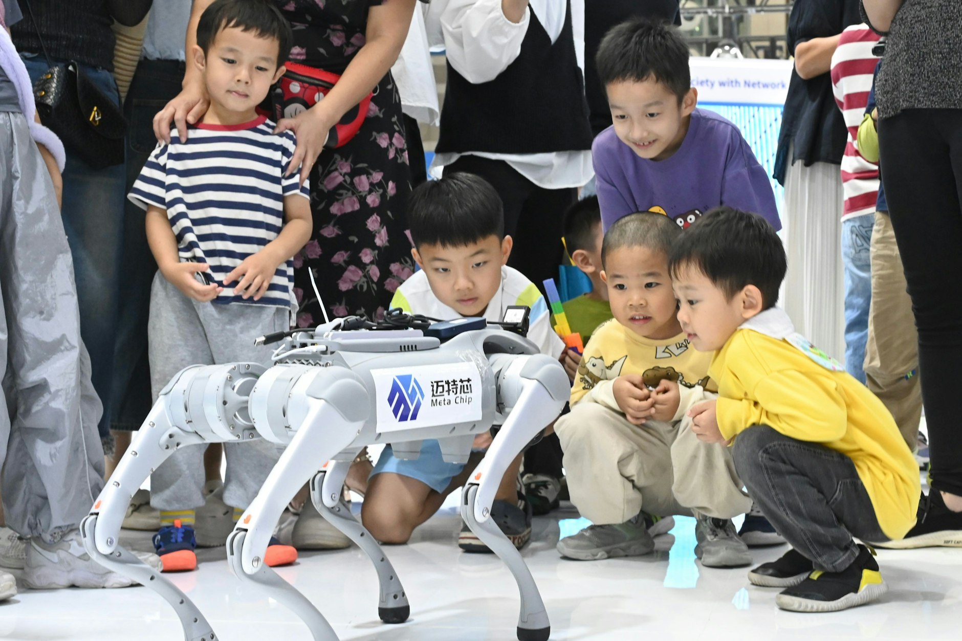 China erlebt einen dramatischen Einbruch der Geburtenrate und setzt zur Betreung der Alten auf Robotik. Diese Kinder in Shenzhen kommen früh in positiven Kontakt mit der neuen Technik.