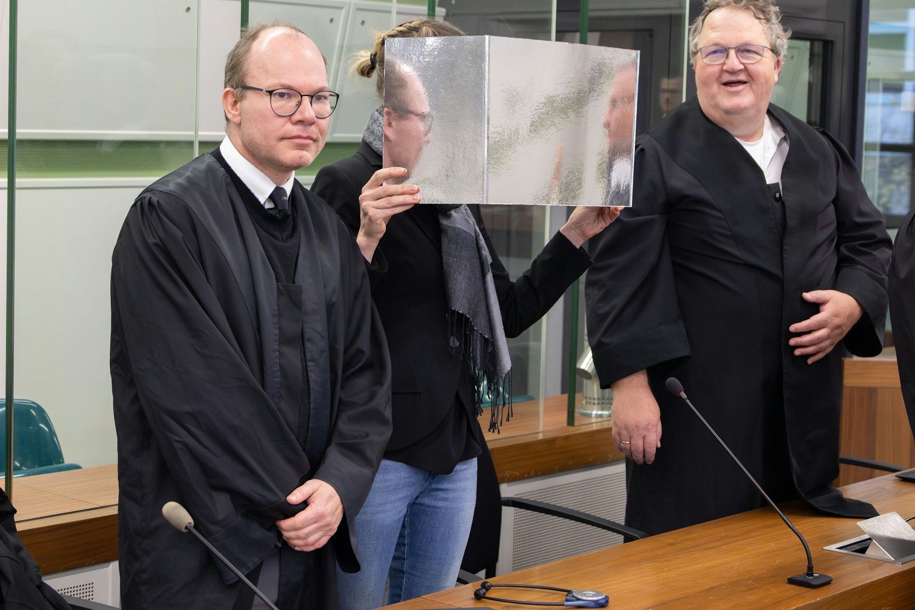 Die mutmaßliche Auto-Schmugglerin neben ihren Anwälten vor Gericht.